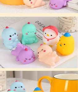 Close-up of colorful soft vinyl dinosaur and animal bath toys on a decorative book