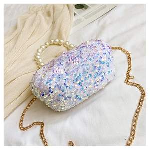 Detailed macro view of white iridescent sequin shell bag with pearl handle and gold chain