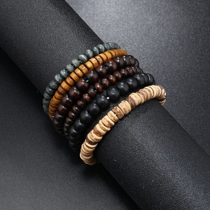 Detailed view of layered multi-colored wooden bead bracelets on a black display cylinder