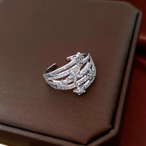 Macro view of silver star open ring with micro-pave zircon on dark brown jewelry box