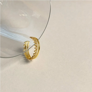 Macro shot of gold double-layer crown ring with zircon detail on a glass edge
