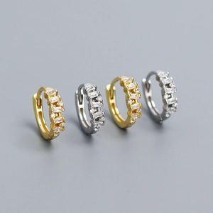 Detailed macro view of gold and silver S925 huggie earrings with rectangular crystals