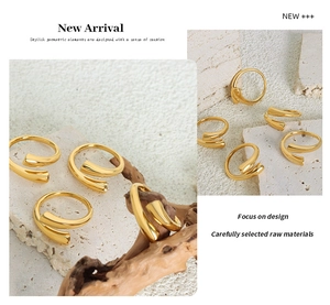 Macro detail of polished gold geometric spiral ring on natural stone and wood