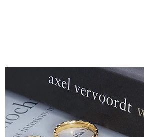 Polished gold U-shaped ring with scallop edges on minimalist black background