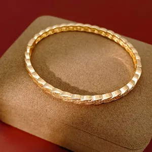 Elegant gold-plated twisted open bangle featuring sparkling cubic zirconia on jewelry box