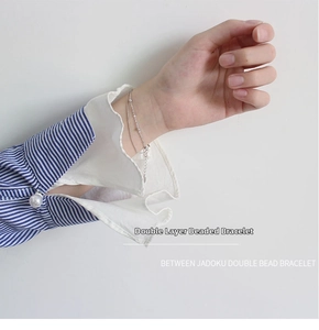 Detail of double-layer S925 sterling silver snake chain bracelet with beads on wrist