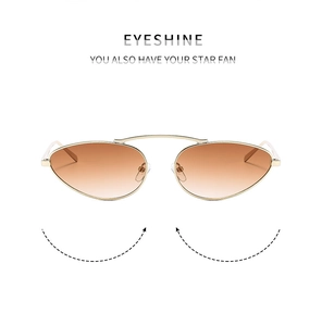Detailed macro view of the gold metal frame and amber gradient lenses on cat eye sunglasses