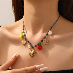 Detail of colorful drip oil heart and sun charms on a braided gold chain necklace