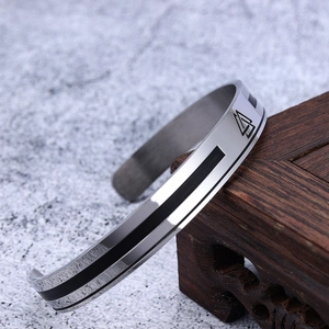 Viking rune stainless steel C-shaped open bracelet with black enamel detail on wood