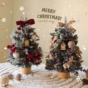 Mini tabletop Christmas trees with LED lights, snow flocking, and wooden base decor