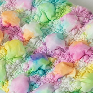 Detailansicht des bunten Tie-Dye-Blasengitterstoffs für Reisekosmetiktaschen