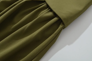 Detail des armee-grünen Schlitzkleides mit geraffter Stoffstruktur und Taillenfalten