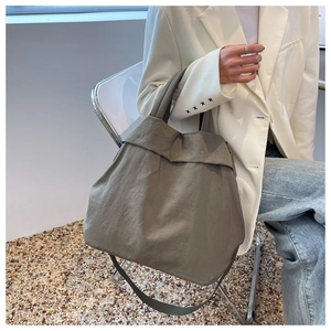 Taupe oversized nylon tote bag shown in a professional lifestyle shot for daily use