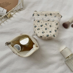 Detailed view of floral canvas makeup bags with elegant lace trim and metal zipper closure