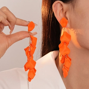 Detail of long orange acrylic petal fringe clip-on earrings with gold chains
