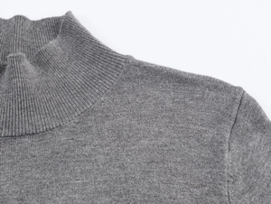 Detail of grey mock neck knit sweater showing high-quality stitching and fine texture