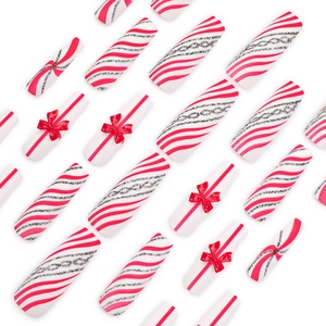 Extra long Christmas press-on nails with red bows, stripes, and silver glitter accents