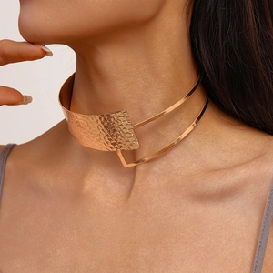 Detailed close-up of a layered gold-plated choker with hammered texture on a model