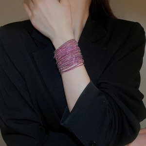 Close-up of pink crystal multi-layer stretch bracelet on model wearing black blazer