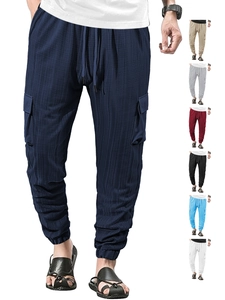 Detail view of cargo pants showing the drawstring waist, linen texture, and side flap pocket