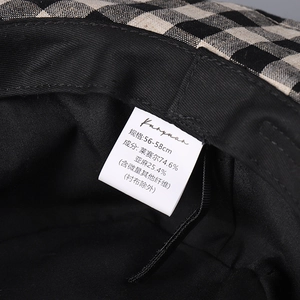 Detail shot of black and beige plaid hat lining with Lyocell and linen material label