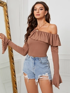 Top marrón con hombros descubiertos y volantes con pantalones cortos vaqueros rotos