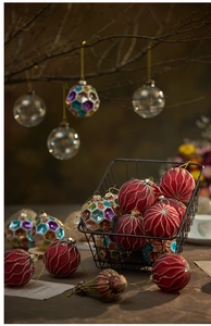 Close-up of glass Christmas ornaments with red stripes and gold glitter decor