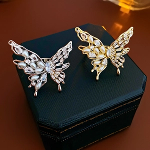 Detail of gold and silver butterfly rings with pearls and zircons on a jewelry box