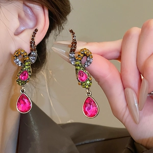 Detailansicht von Vintage Schlangenohrringen mit bunten Kristallen und rosa Tropfen