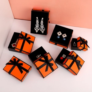 Orange jewelry gift boxes with black ribbon bows in various sizes for rings and necklaces