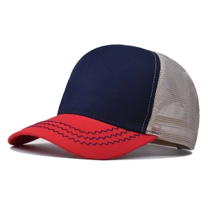 Detail of tricolor mesh trucker hat featuring red brim with navy wavy stitching accents