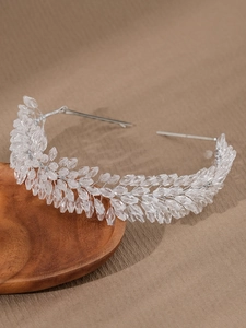 Macro shot of bridal crystal headband with leaf patterns on silver metal frame