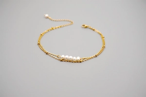 Close-up of double-layer gold titanium steel bracelet with freshwater pearls