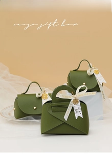 Detail of stone green leather wedding gift boxes with gold studs and love ribbons