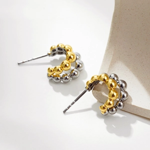Detail of dual-layer C-shaped beaded hoop earrings with gold and silver polished beads