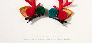 Detail of plush red reindeer antler hair clips with festive pom-poms for Christmas styling