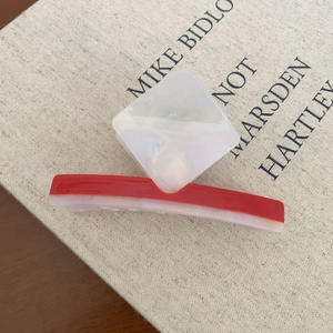 Red and marble white acetate hair claw clip with modern rectangular color-block design