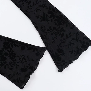 Detail of black chiffon flared sleeve with flocked floral patterns and wavy edges