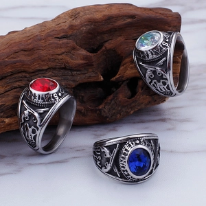 Detailed close-up of US Navy military rings featuring colorful inlaid stones on wood