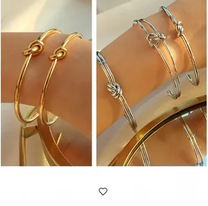Dettaglio di bracciali aperti a forma di C con nodo a vite vintage oro e argento