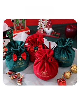 Detail of velvet Christmas drawstring gift bags with gold lettering and decorative bows
