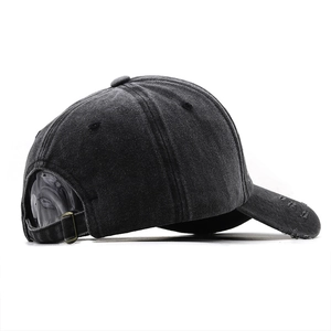 Detail of vintage black baseball cap showing distressed brim and metal adjustable buckle