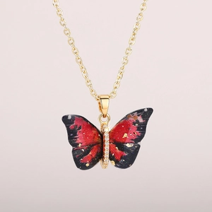 Macro detail of butterfly pendant with red and black marble texture and gold leaf accents
