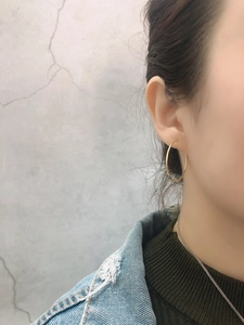 Close-up of minimalist gold S925 sterling silver hoop earring worn by a model in denim