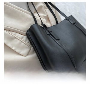 Close-up of black lychee grain leather fabric on a large commuter tote bag