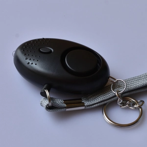 Detail view of black personal safety alarm featuring LED light and a grey braided lanyard