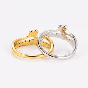 Close-up of double-layered heart rings with pavé diamonds in gold and silver finish