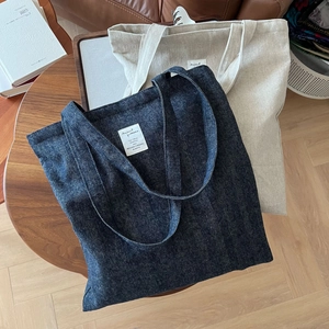 Gros plan de sacs cabas en denim et toile sur une table en bois avec un design vintage