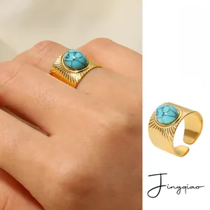 Detail of 18K gold plated stainless steel ring featuring oval turquoise and ribbed band