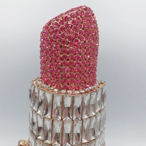 Macro shot of lipstick clutch bag featuring pink rhinestones and crystal body texture